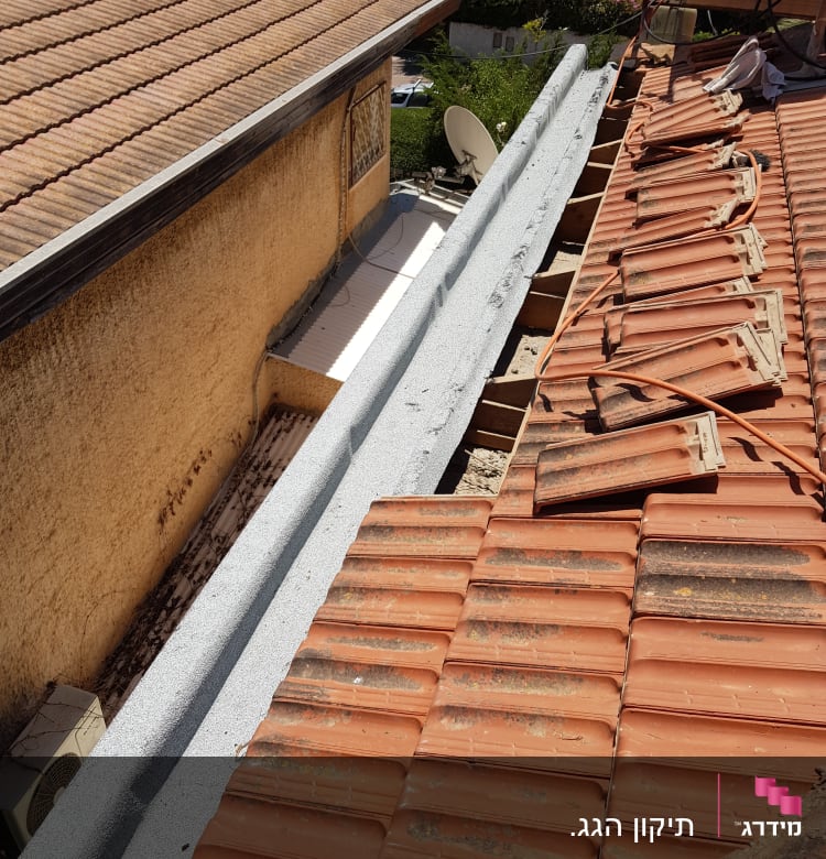 רעפים כתומים על גג עם תיקונים וחוטים